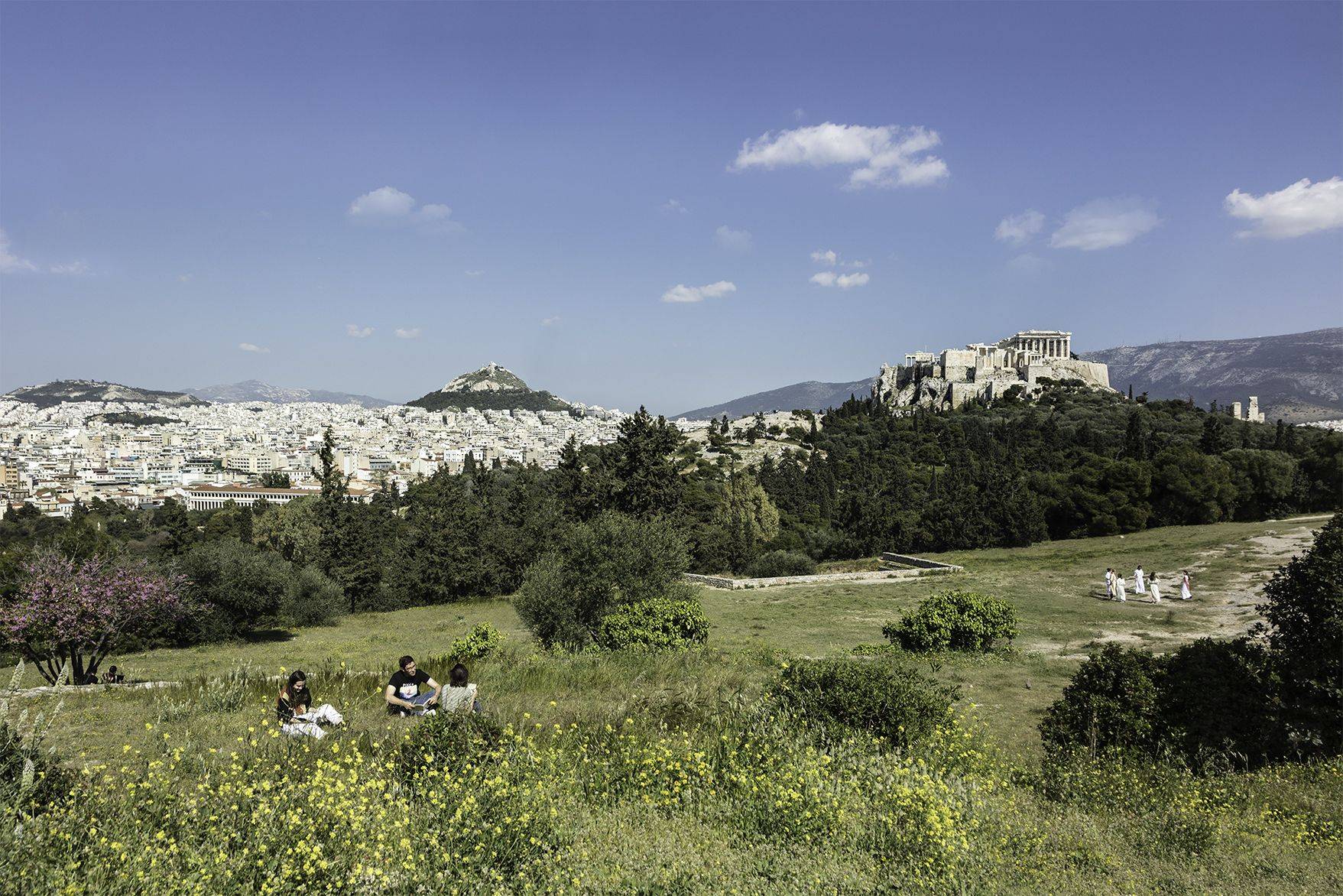 CYA - College Year in Athens 1. CYA Students on the Pnyx. The Acropolis of Athens and Lycabettus hill are visible in the background